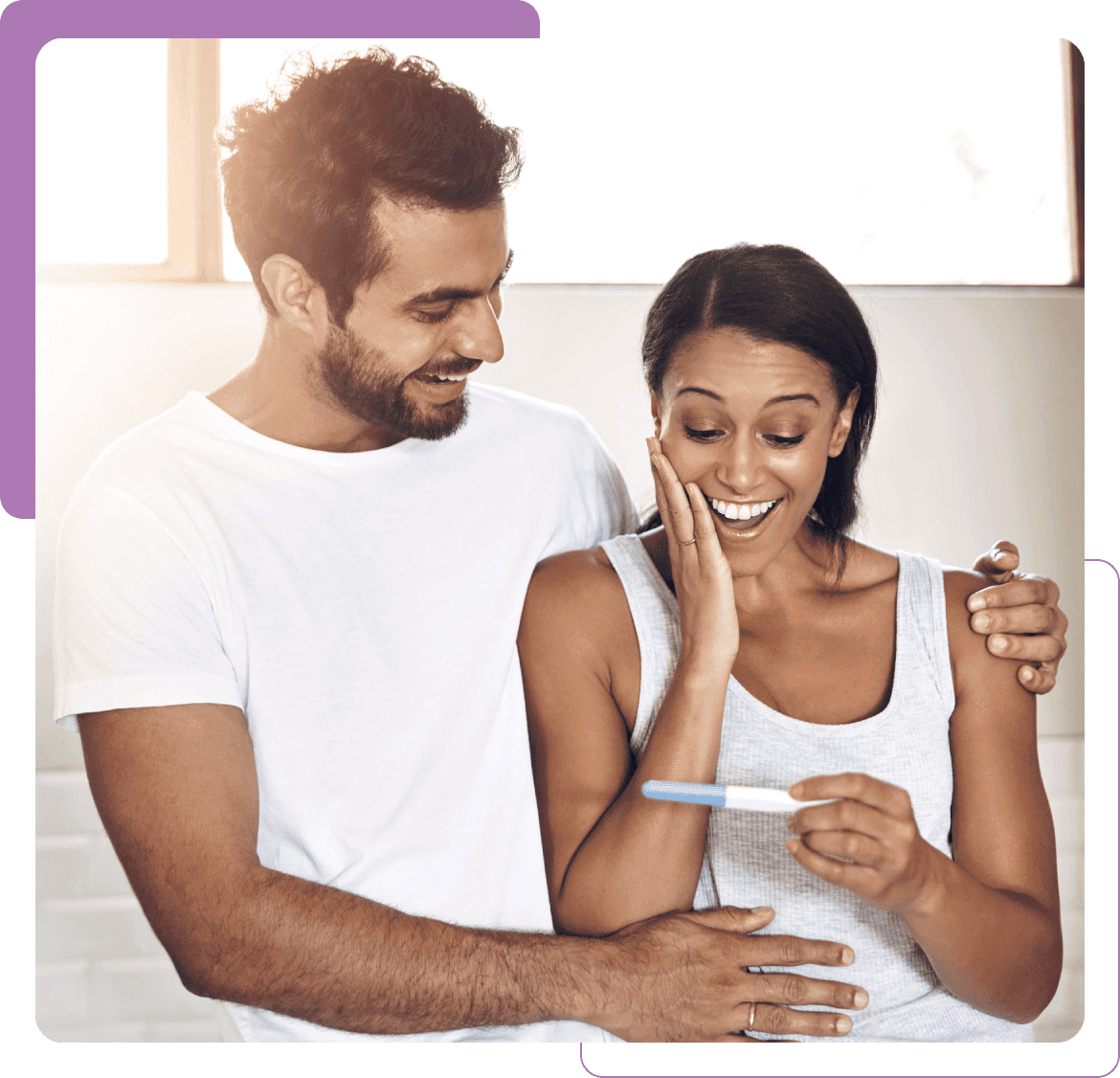 Happy couple looking at home pregnancy test