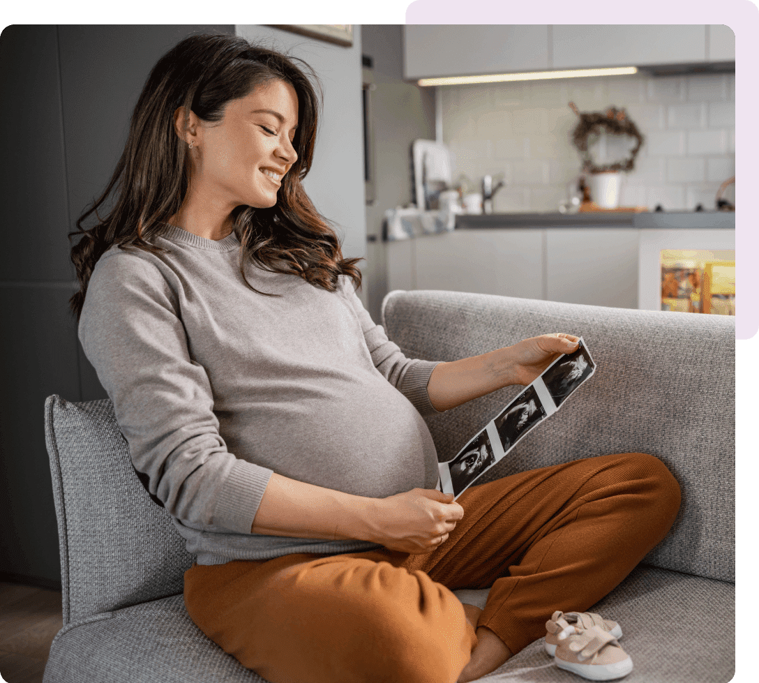Pregnant woman smiling at ultrasound photos