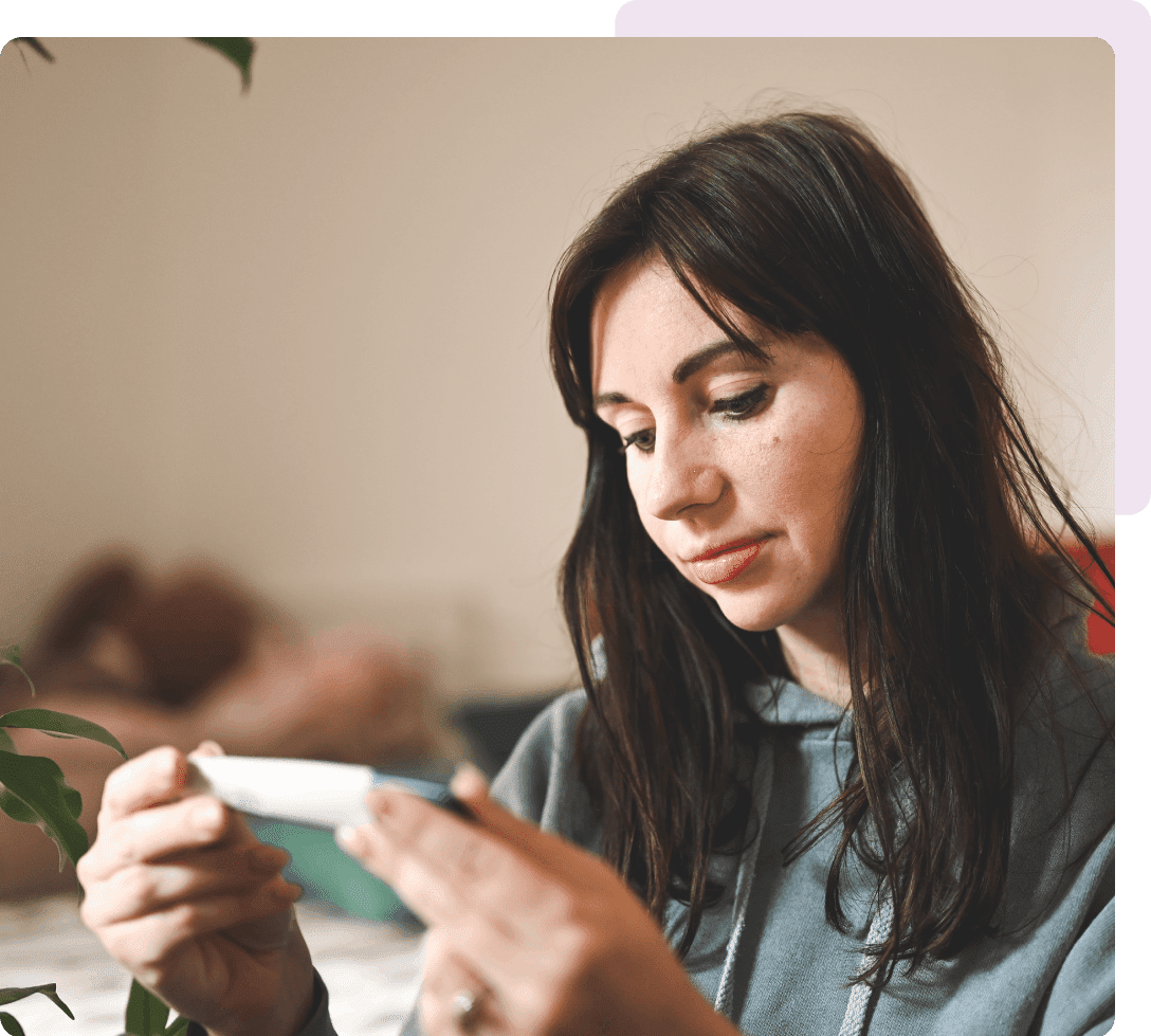 Woman examining small white handheld device