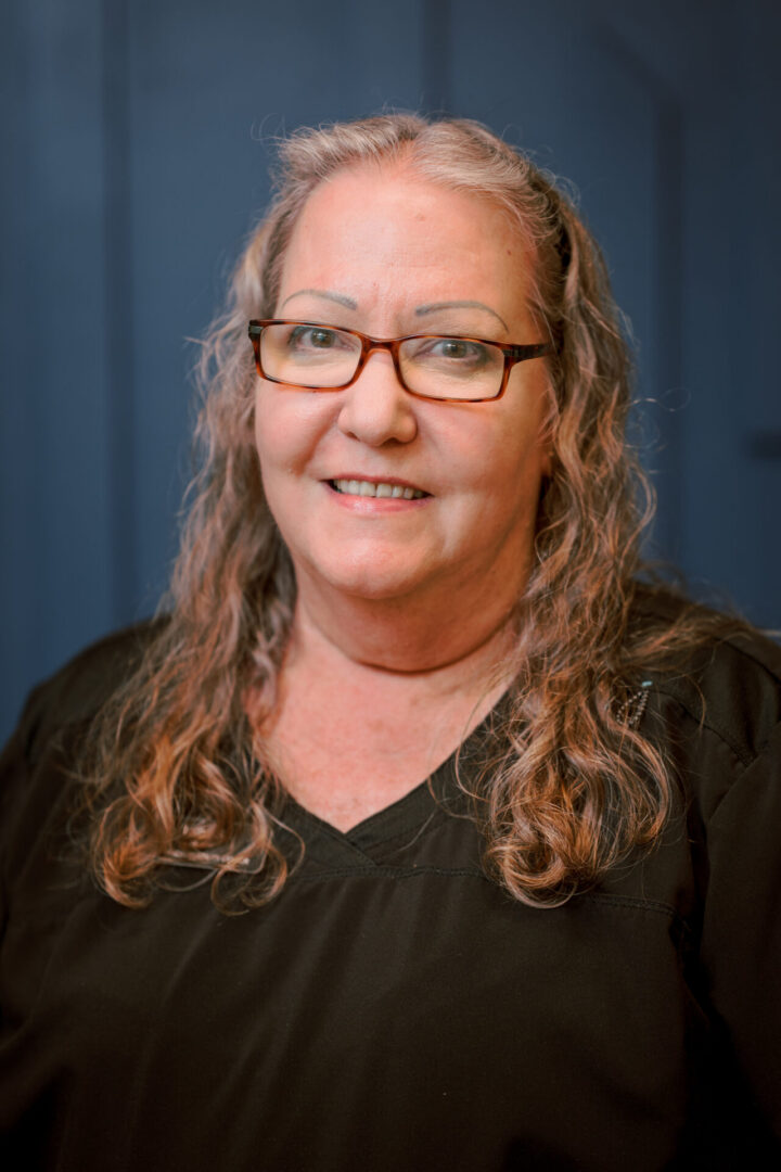 Portrait of a woman in dark top.