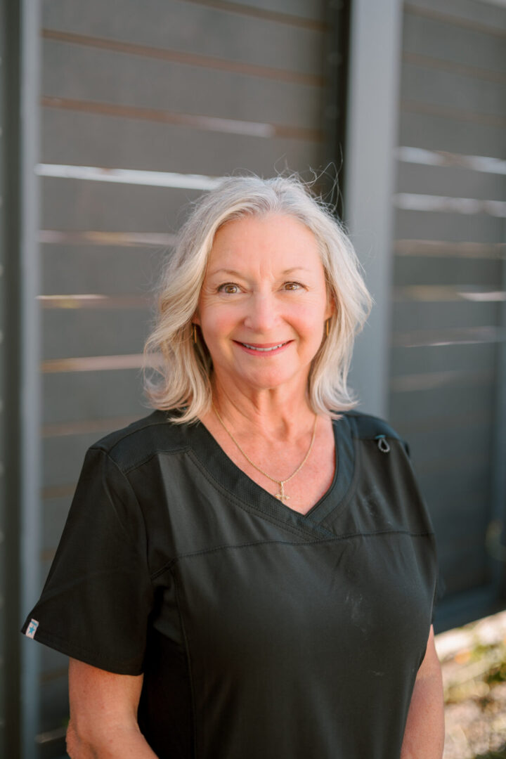 Mature woman smiling near modern fence