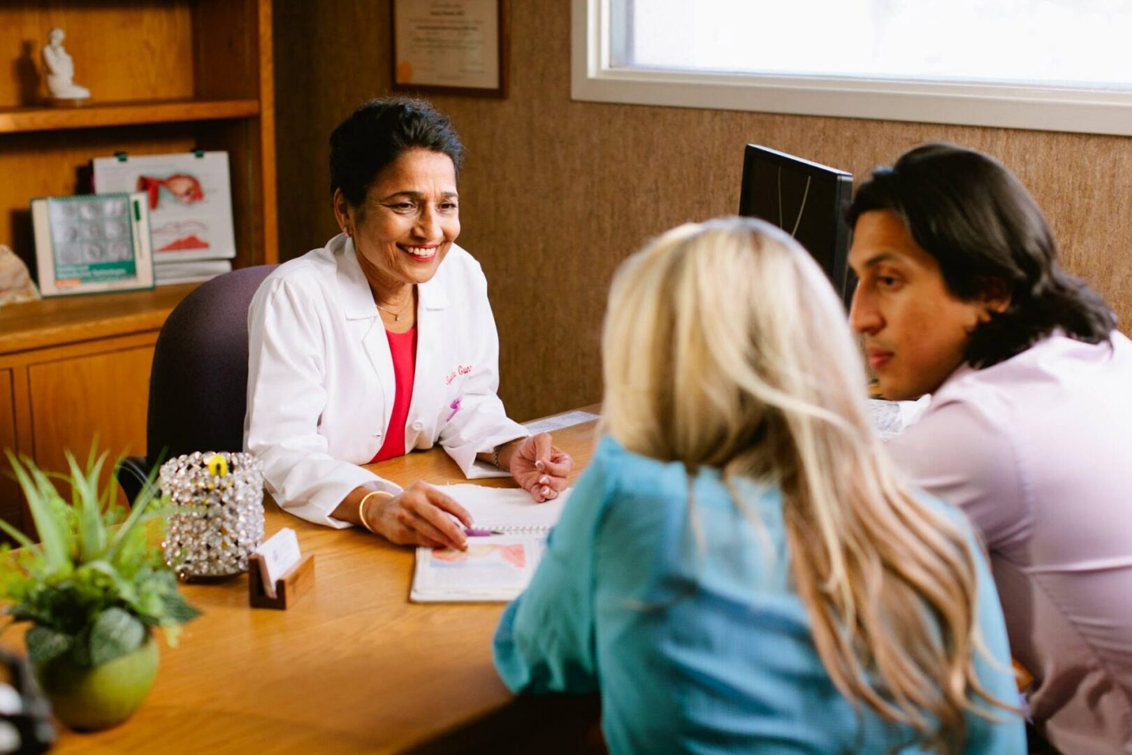 Doctor consulting with couple in office.