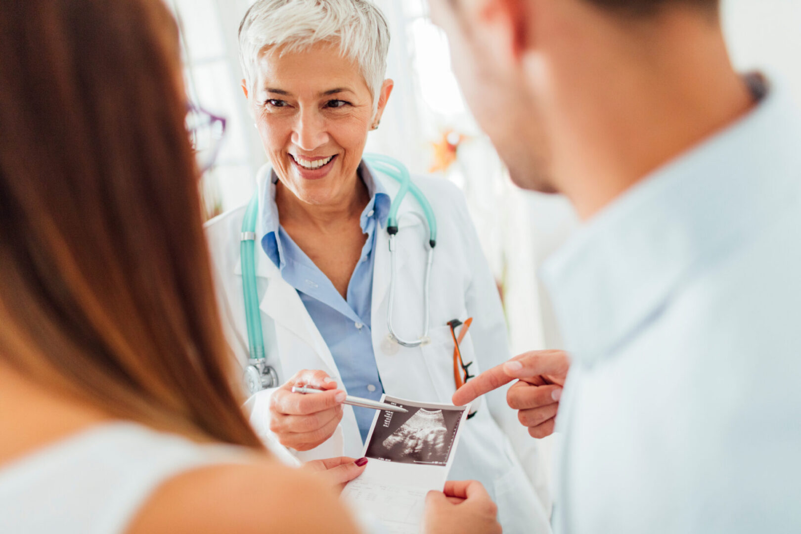 Doctor showing ultrasound to expecting couple