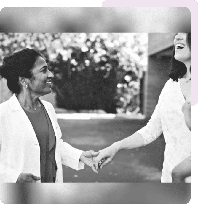 Two women holding hands and smiling