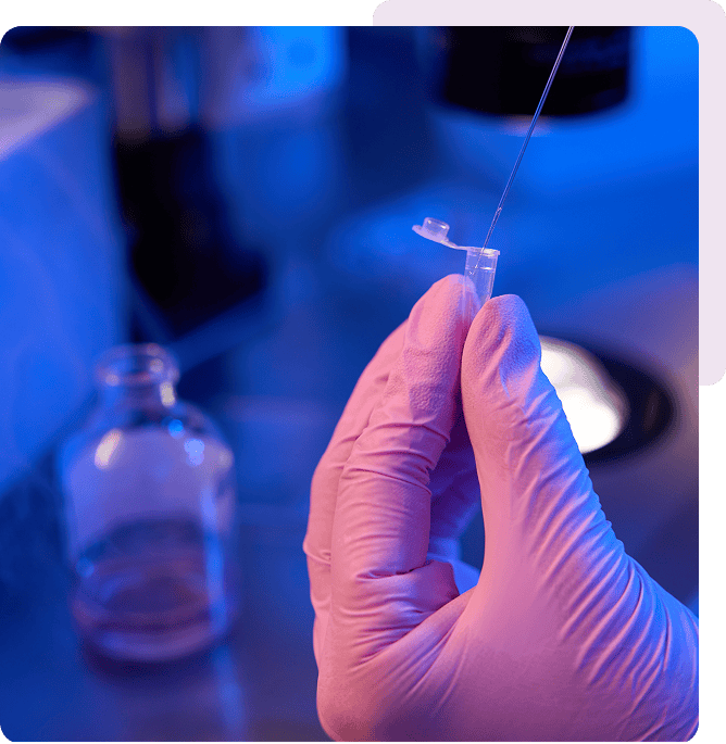 Gloved hand holding laboratory pipette